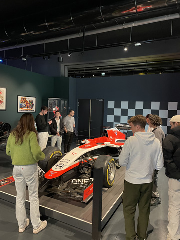 étudiants regardant une voiture de course, dans un musée